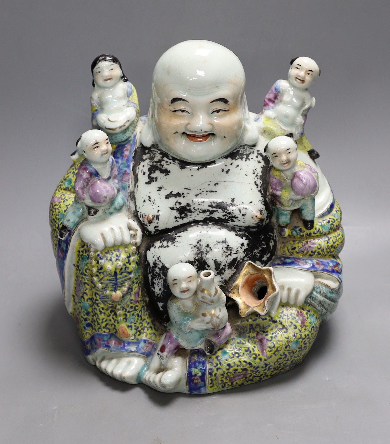 An early 20th century enamelled porcelain figure group of a seated Budai and children, 27.5cm high
